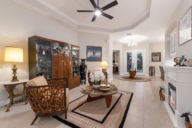 living room featuring a glass covered fireplace, light tile patterned flooring, crown molding, and baseboards