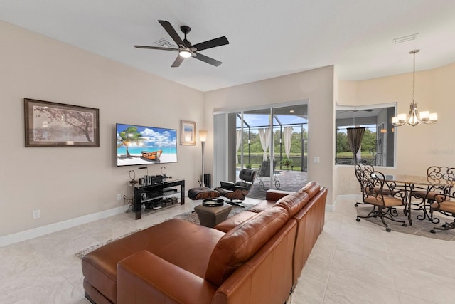 living room featuring light tile patterned floors, visible vents, baseboards, and ceiling fan with notable chandelier