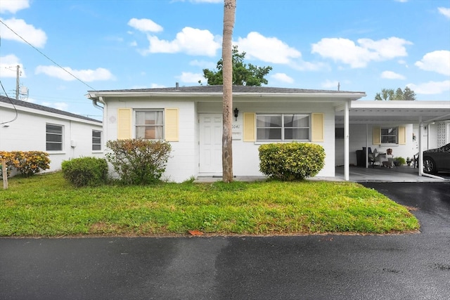 view of front facade with a front lawn and a carport