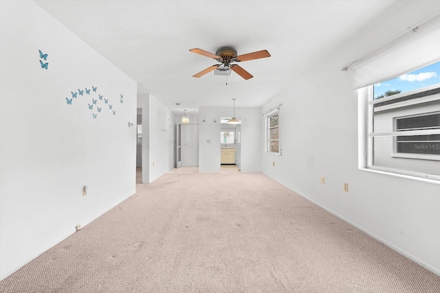 unfurnished living room with a ceiling fan and light colored carpet