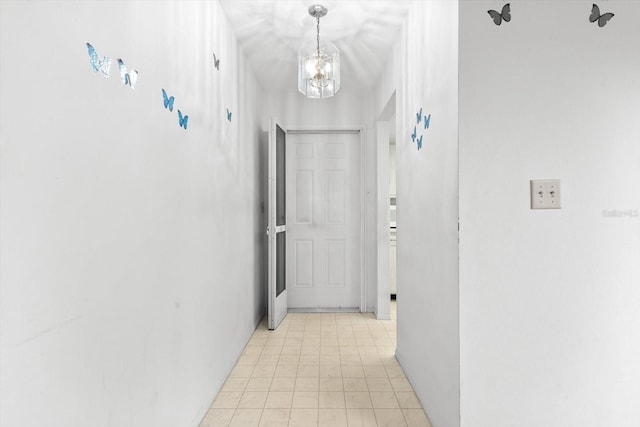 corridor with an inviting chandelier and light tile patterned floors