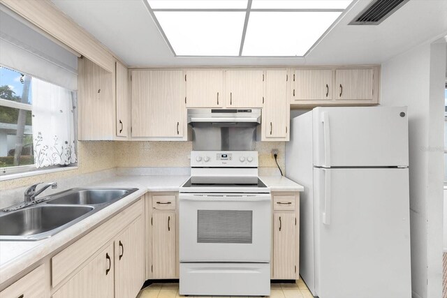 kitchen featuring electric stove, white refrigerator, backsplash, light tile patterned floors, and sink