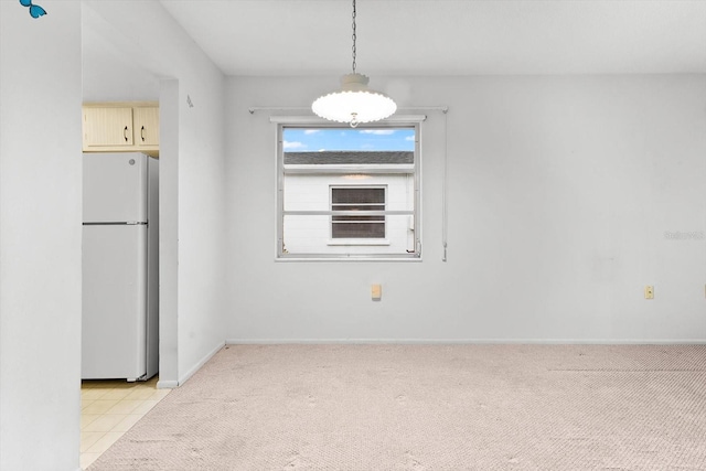 unfurnished dining area with light carpet and baseboards