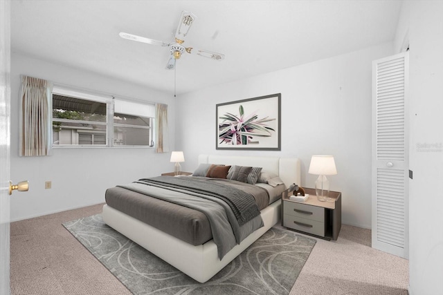 carpeted bedroom featuring ceiling fan and a closet