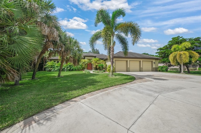 view of front of house featuring a garage, a front lawn, driveway, and stucco siding