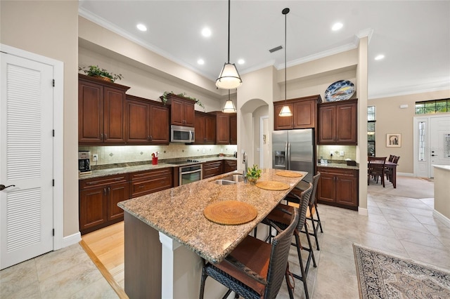 kitchen with ornamental molding, arched walkways, appliances with stainless steel finishes, and a sink