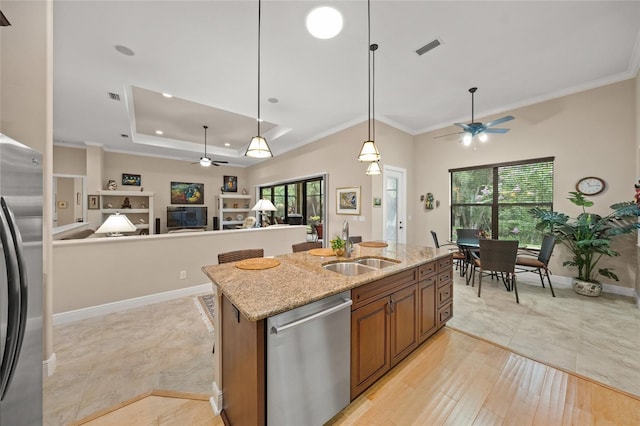 kitchen featuring visible vents, open floor plan, brown cabinets, appliances with stainless steel finishes, and a sink