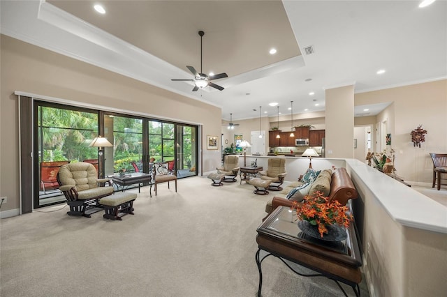 living area with visible vents, baseboards, crown molding, a raised ceiling, and light colored carpet