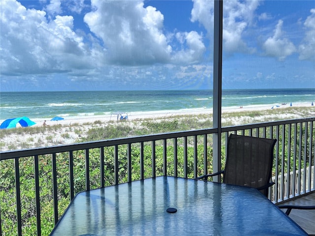 balcony featuring a water view and a beach view