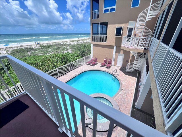 view of swimming pool featuring a water view and a beach view