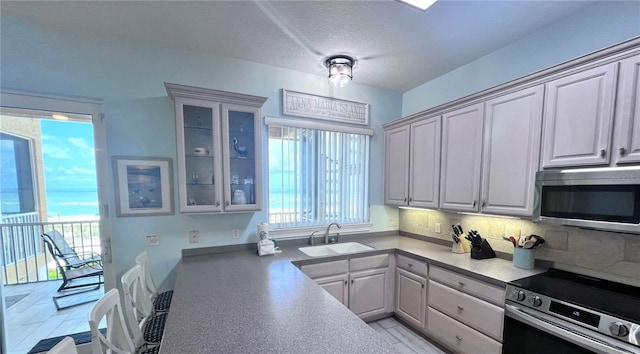 kitchen with white cabinetry, sink, backsplash, and stainless steel appliances