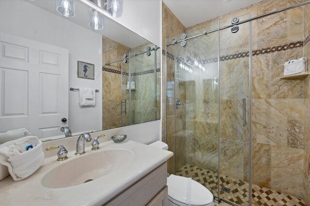 bathroom featuring vanity, a shower with door, and toilet