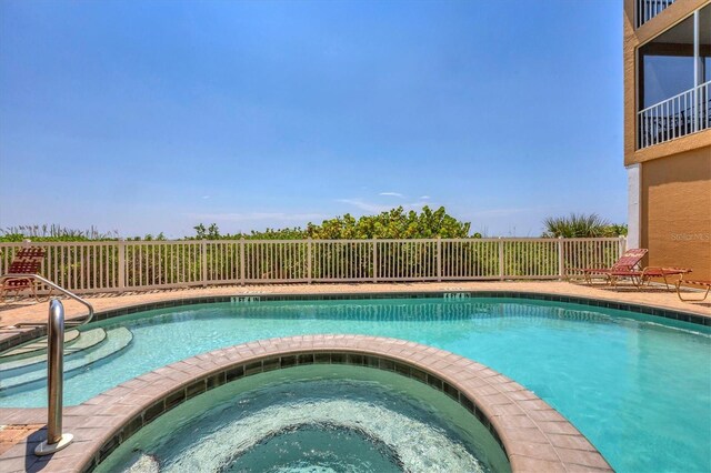 view of swimming pool featuring an in ground hot tub