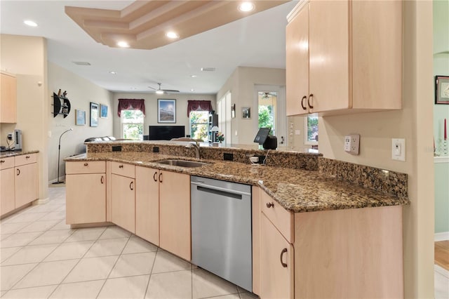 kitchen with ceiling fan, stainless steel dishwasher, sink, dark stone counters, and light brown cabinetry