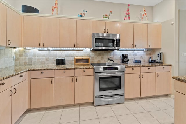 kitchen featuring light brown cabinets, stainless steel appliances, and backsplash