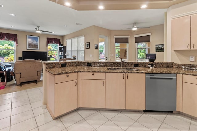 kitchen featuring dark stone counters, a wealth of natural light, sink, and dishwasher