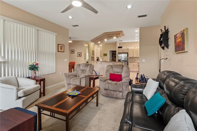 carpeted living room with ceiling fan