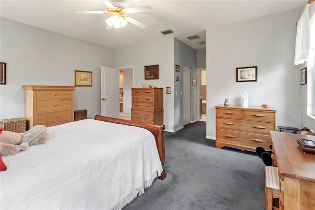 bedroom with ceiling fan, connected bathroom, and dark colored carpet