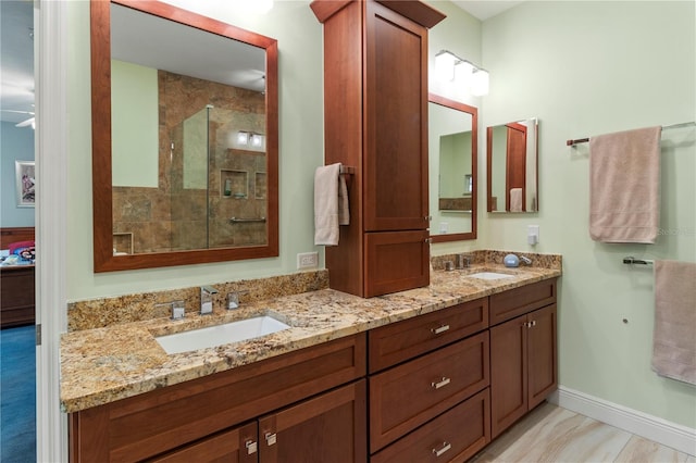 bathroom featuring ceiling fan, tiled shower, and vanity