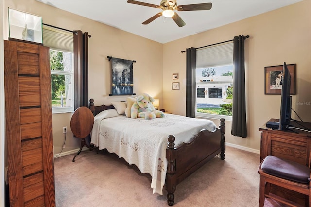 carpeted bedroom featuring multiple windows and ceiling fan