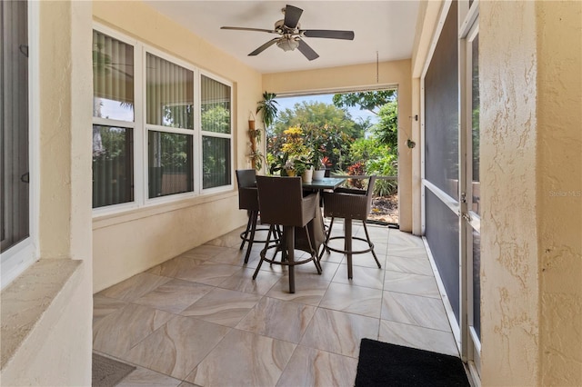 sunroom / solarium featuring ceiling fan