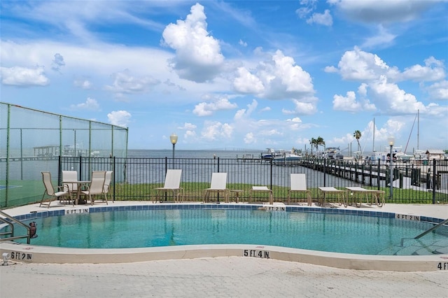 view of pool featuring a water view and a patio area