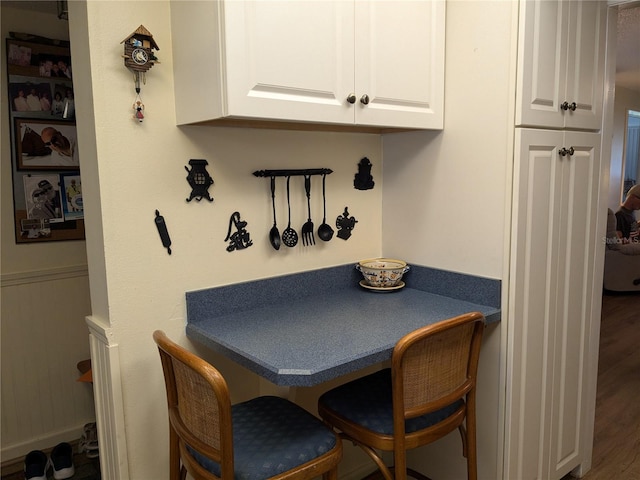 dining space featuring a wainscoted wall and wood finished floors