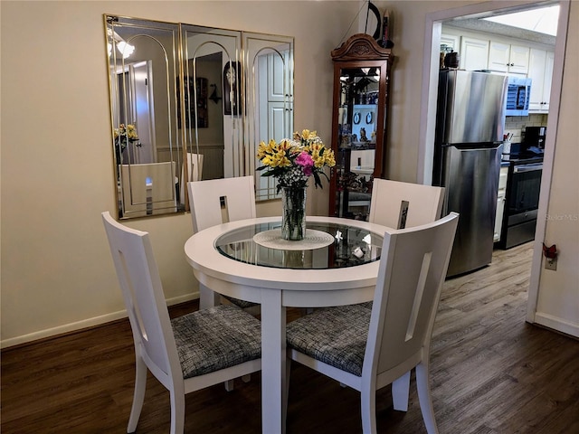 dining space featuring wood finished floors and baseboards