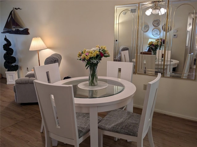 dining area with baseboards and wood finished floors