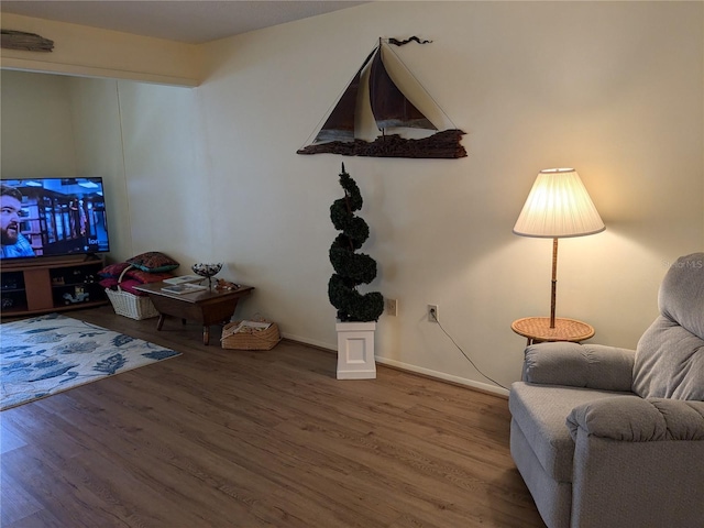 sitting room featuring baseboards and wood finished floors