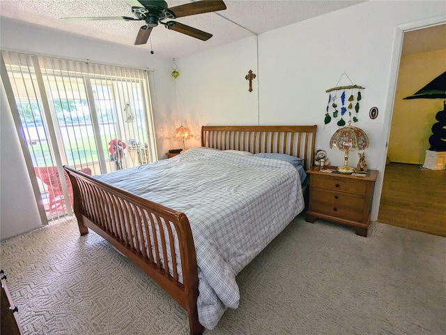 bedroom with a textured ceiling, carpet, a ceiling fan, and access to exterior