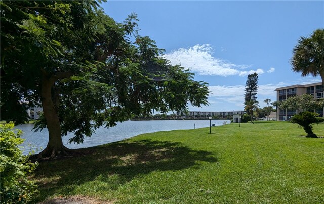 view of home's community with a water view and a yard