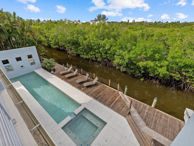 dock area featuring a water view and a pool with hot tub