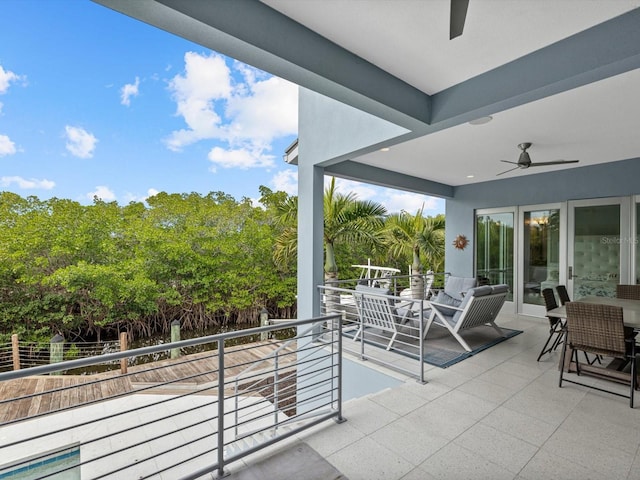 view of patio / terrace featuring a balcony, a ceiling fan, and outdoor dining space