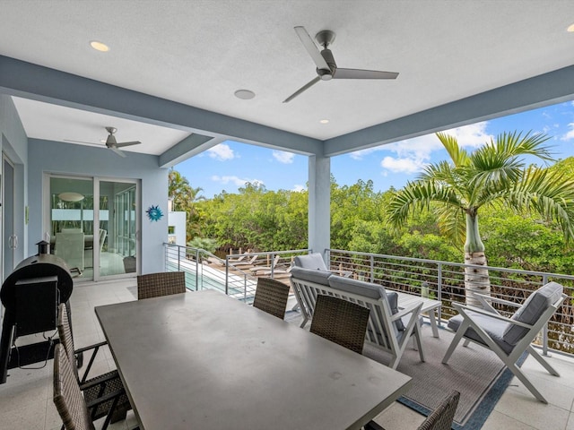 view of patio / terrace with a balcony, ceiling fan, and outdoor dining area