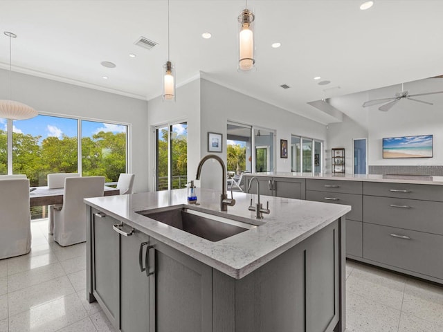 kitchen with recessed lighting, gray cabinets, a sink, and a center island with sink