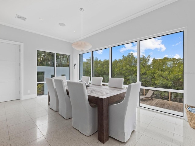 dining room with light speckled floor, ornamental molding, visible vents, and baseboards