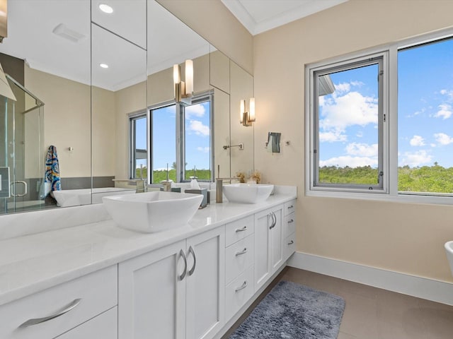 full bath with a stall shower, a sink, and a wealth of natural light