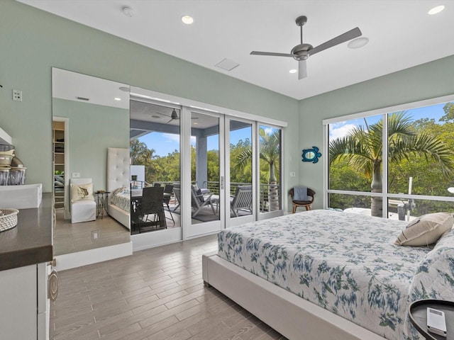 bedroom featuring access to outside, multiple windows, recessed lighting, and wood finished floors