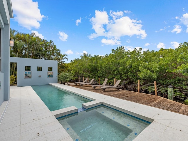 view of swimming pool featuring a deck, a patio, and a pool with connected hot tub