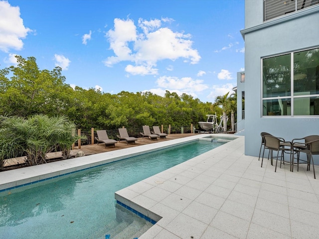 view of swimming pool featuring a pool with connected hot tub and a patio area