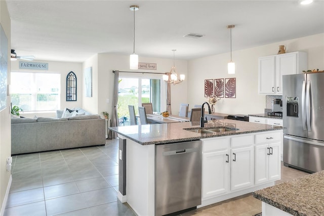 kitchen featuring ceiling fan with notable chandelier, a center island with sink, appliances with stainless steel finishes, sink, and white cabinets