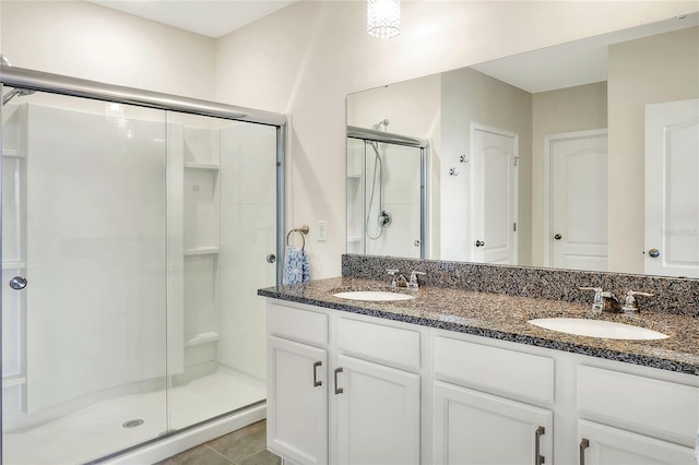 bathroom with tile patterned flooring, walk in shower, and vanity