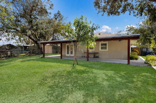 back of house with a patio area, a lawn, and a playground