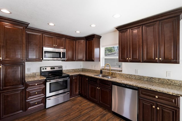 kitchen featuring dark wood-type flooring, stainless steel appliances, dark brown cabinets, sink, and light stone counters