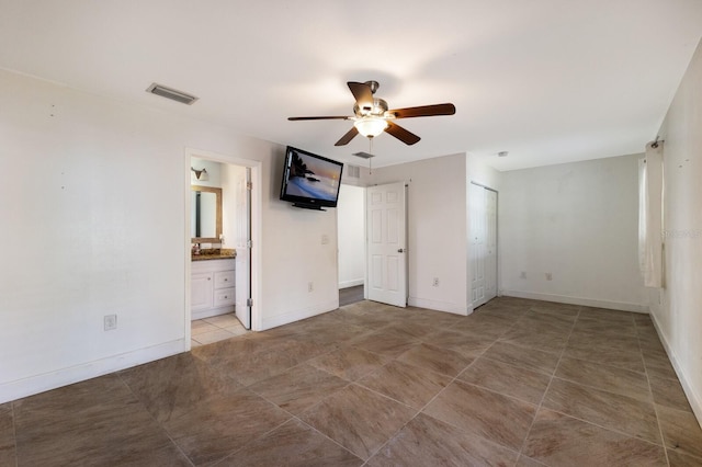 unfurnished bedroom featuring connected bathroom, ceiling fan, and tile patterned floors