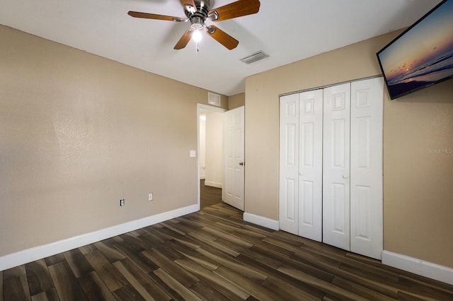 unfurnished bedroom featuring a closet, dark hardwood / wood-style floors, and ceiling fan