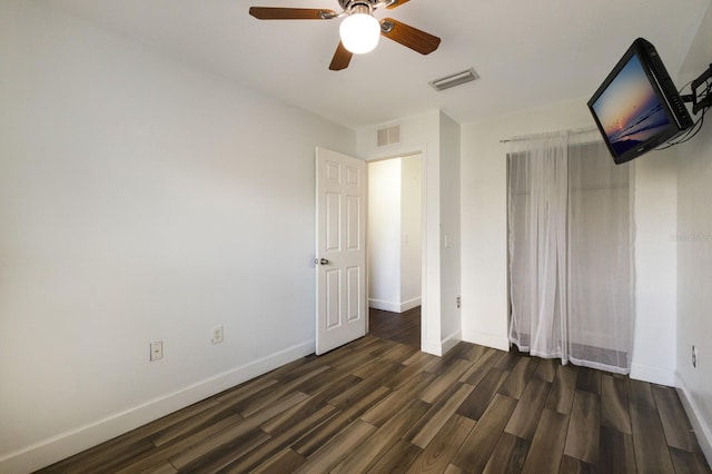 unfurnished bedroom featuring ceiling fan and dark hardwood / wood-style flooring