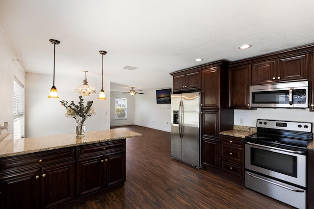 kitchen with light stone countertops, dark brown cabinets, stainless steel appliances, pendant lighting, and dark wood-type flooring