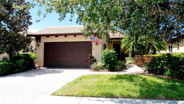 view of front of house featuring a garage and a front lawn